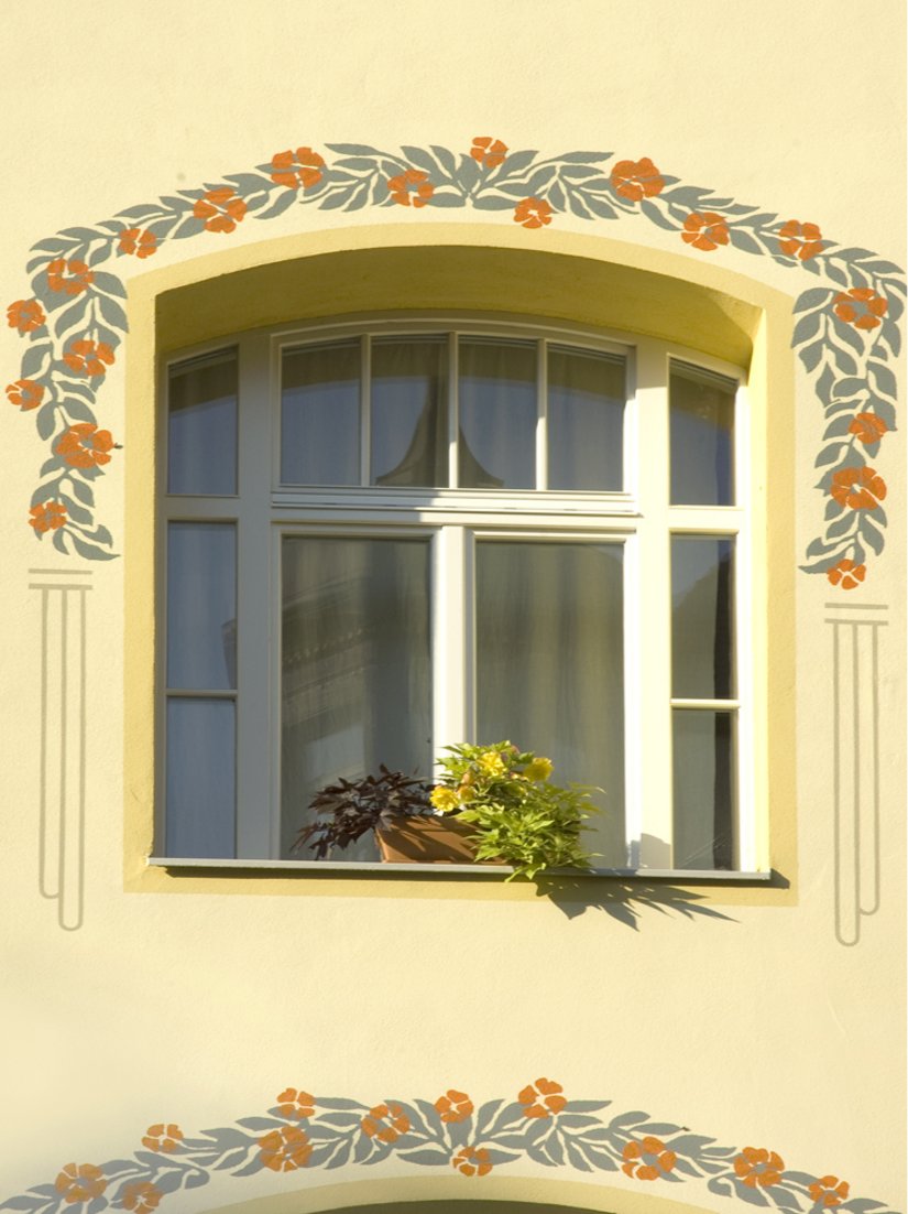 Mit Liebe zum Detail umrahmt ein in Grün und Orange gehaltener Blumenrahmen die Fenster, der den Stil der 60er Jahre unterstreicht.