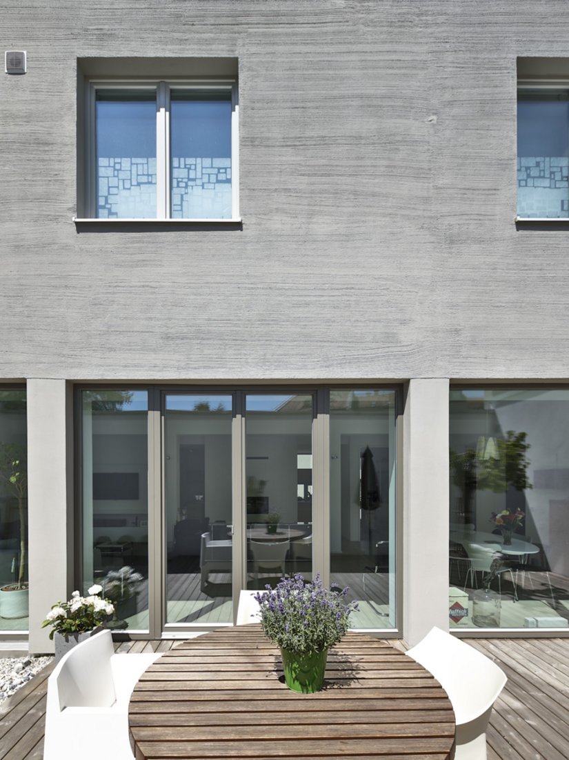 Die Terrasse wurde mit gräulichem Holz gestaltet, welches mit der Fassade harmoniert.