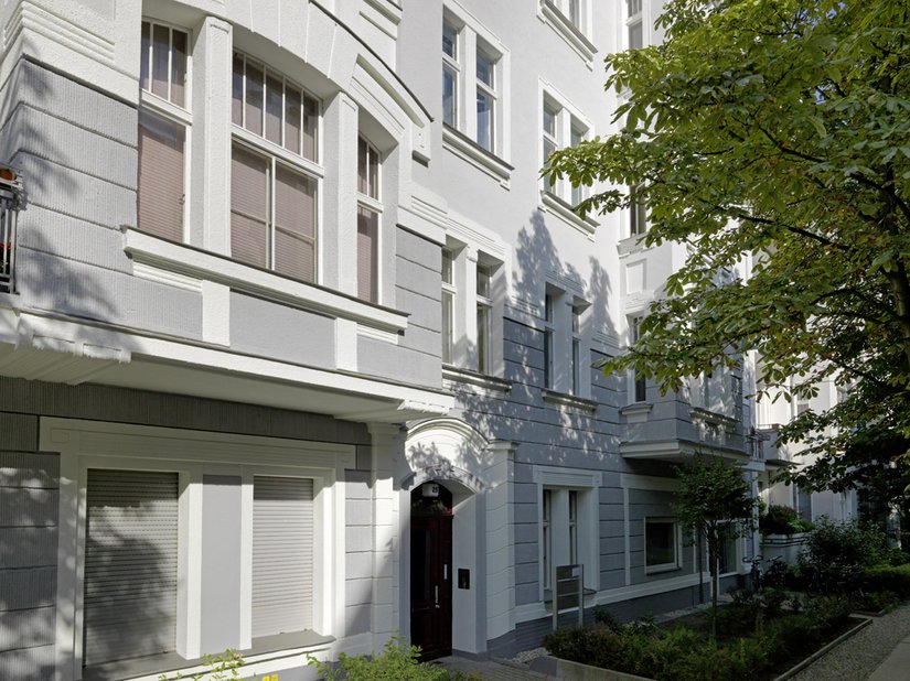 Der dunkel abgesetzte Sockel reicht über die Hälfte des zweiten Geschosses hinaus und bindet dort die Fenster gewissermaßen ein.