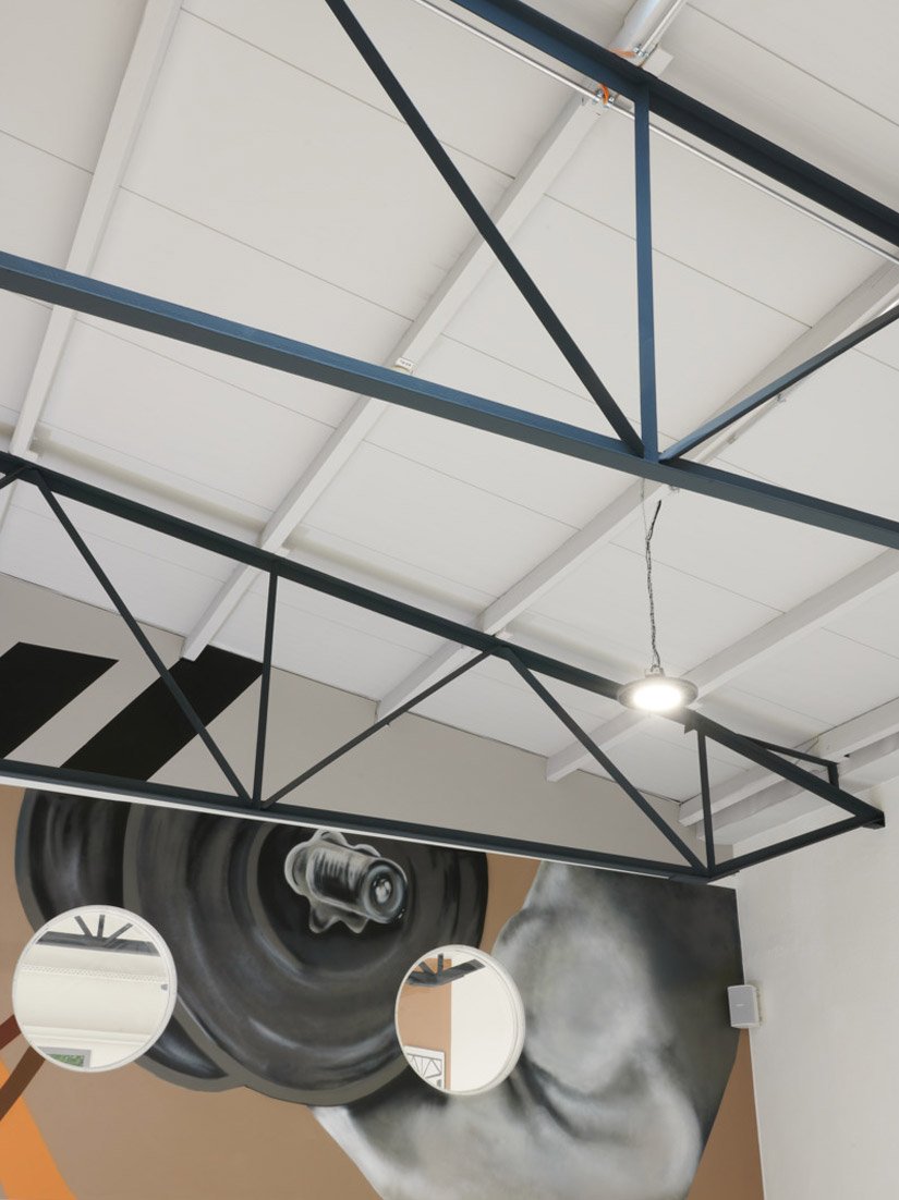 Während die Decke des MediGym mit Flex-Deck 1026 in einem hellgrauen Farbton gespritzt wurde, wurden die dekorativen Eisenträger in einem dunklen Anthrazit gestaltet, um den Industrielook zu verstärken.