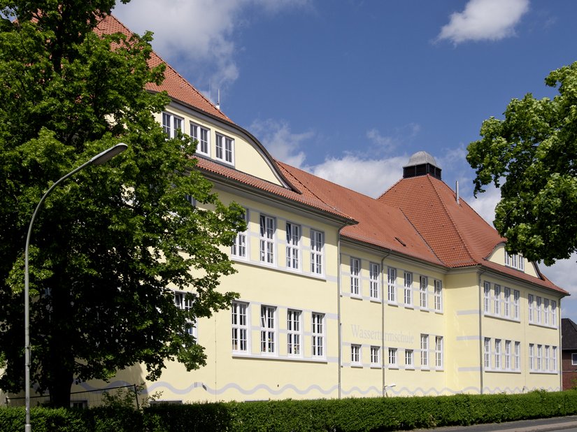 In Anlehnung an historische Farbigkeiten wurde ein heller Ockerton für das Hauptgebäude gewählt. Dieser wird durch hellgraue Bänderungen im Bereich der Fenster gegliedert.