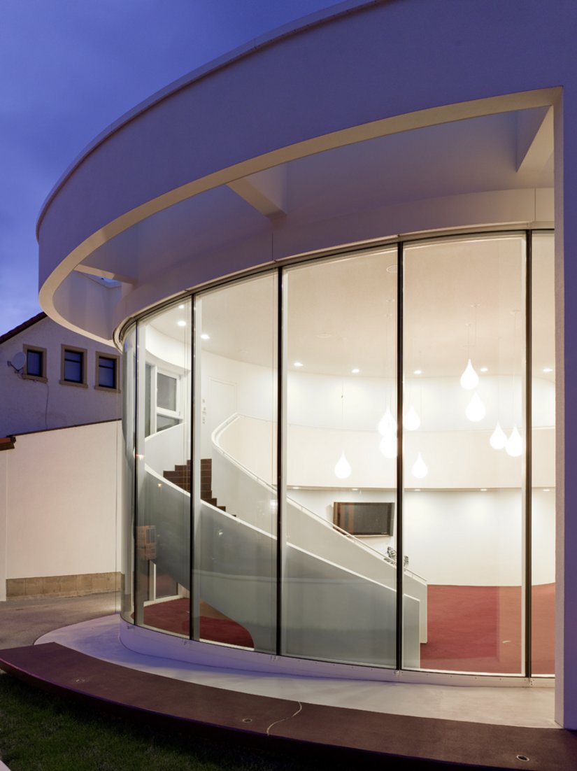 Mit ihrer plastisch modellierten Treppenskulptur und den Leuchttropfen am Deckenhimmel bildet die Eingangshalle ein räumliches Highlight.