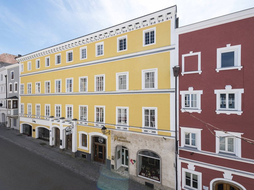 Die Farbabstimmung Ockergelb mit Grau bzw. das Nachbarhaus mit einem herrlichen Ziegelrot verbinden die Haushälften.