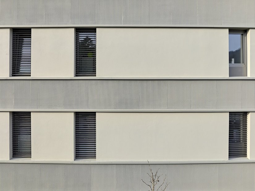 Vertikale Fliesen und mit Kammzugtechnik strukturierte Putzbänder mit&nbsp; Mineral-Leichtputz G 3679 erzeugen eine spannungsvolle Fassadengestaltung, die Alt und Neu perfekt verbinden